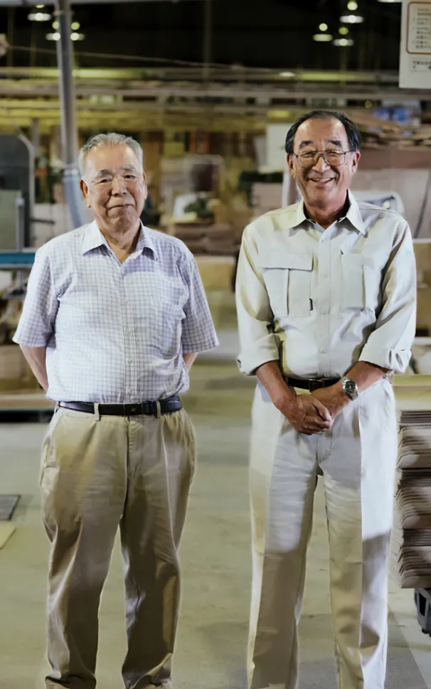 高橋氏（左）と、事業を引き継いだ北日本ボード工業の半田社長（右）
