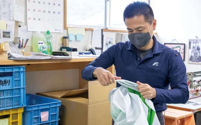 典子さん直伝の技を学ぶフレック工場長補佐の向井さん